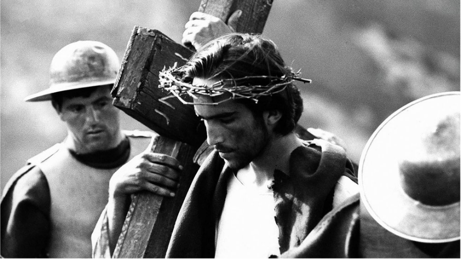 義大利名導帕索里尼拍攝的電影《馬太福音》中，耶穌背起十字架。（圖／影片截圖）